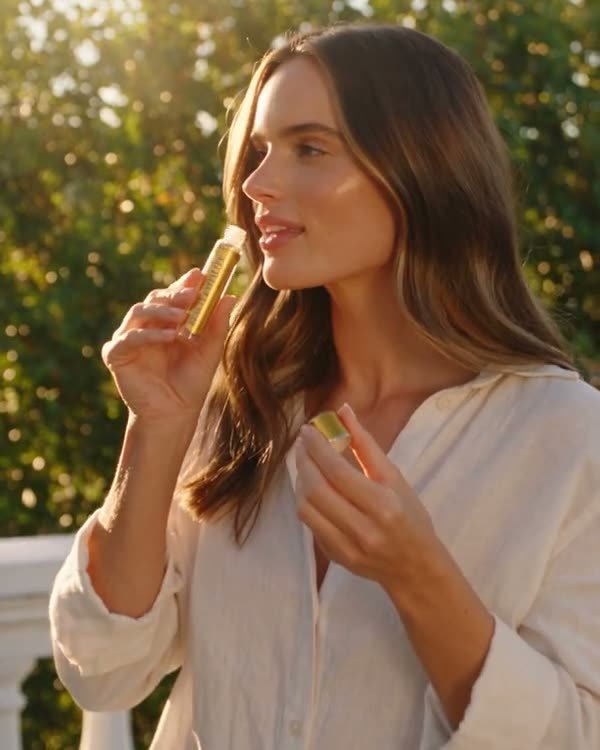 A woman sipping a Longevity Shot outdoors in the morning light